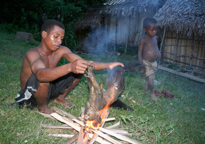 Местный житель готовит убитую руконожку Ай-ай